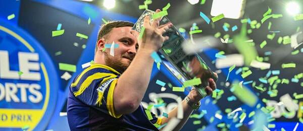 Šipkař Luke Littler s trofejí pro vítěze World Grand Prix Darts organizace PDC
