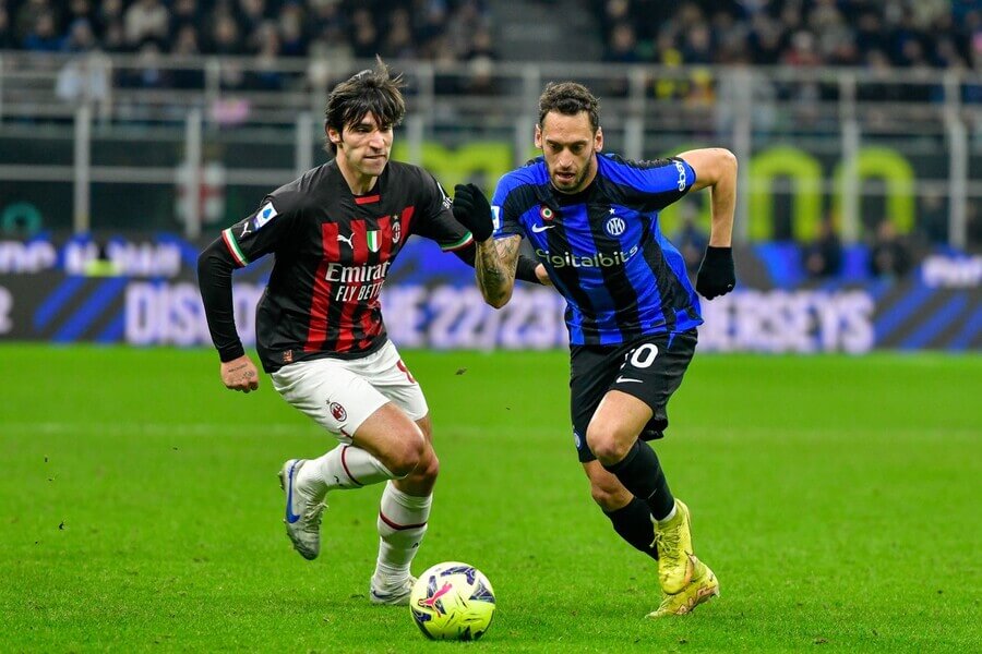 Sandro Tonali a Hakan Çalhanoğlu bojují o míč v ligovém derby