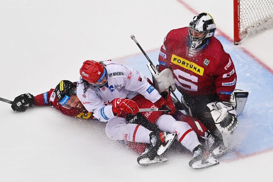 Semifinále play off 2024 mezi Spartou a Třincem je plné ostrých soubojů, zde Ocelář Daniel Voženílek a Sparťané David Němeček a brankář Jakub Kovář