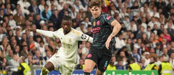 John Stones (Manchester City) a Eduardo Camavinga (Real Madrid) v souboji o míč