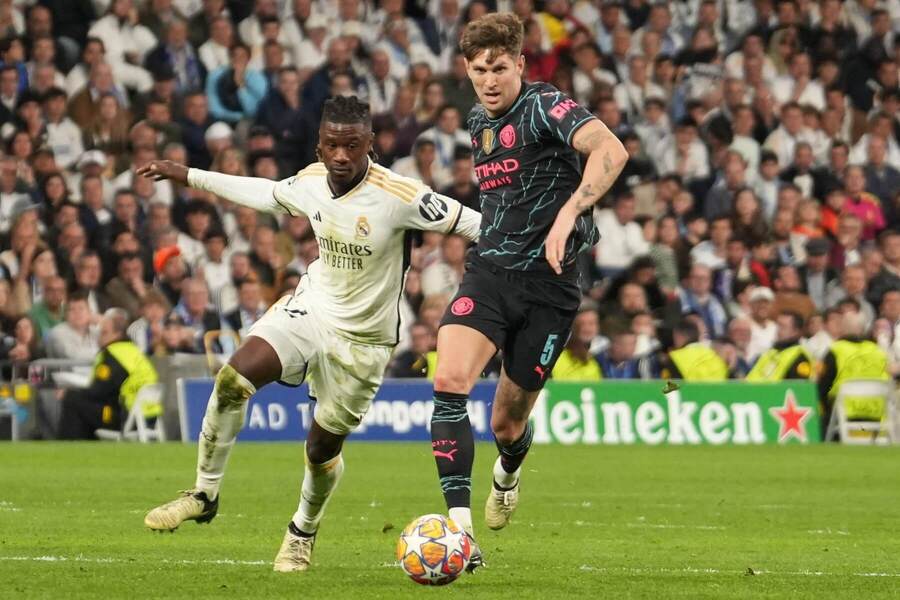 John Stones (Manchester City) a Eduardo Camavinga (Real Madrid) v souboji o míč