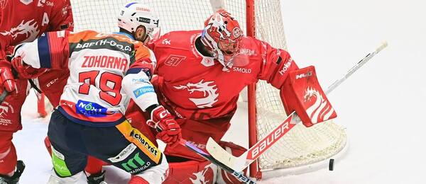 Hokej, extraliga 2024/25, Marek Mazanec (Třinec) kryje puk před Tomášem Zohornou (Pardubice). Oceláři a Dynamo spolu hrají i dnes