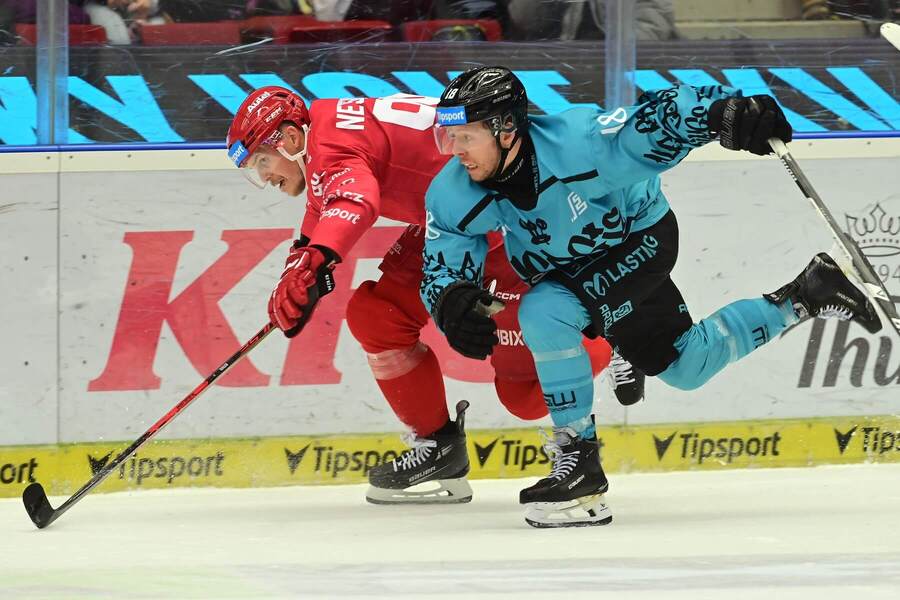 Třinecký útočník Andrej Nestrašil bojuje o&nbsp;puk s&nbsp;Nicholasem Jonesem z&nbsp;Karlových Varů