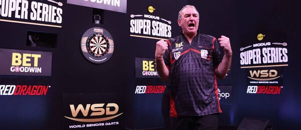 Richie Burnett slaví vítězství u šipkařského terče během turnaje Modus Super Series