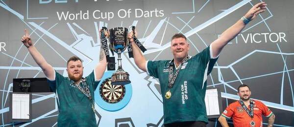 Josh Rock a Daryl Gurney po vítězství na World Cup of Darts 2025. Letošní ročník MS v šipkách týmů můžete sledovat živě online i v TV.
